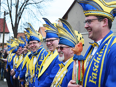 Mitglieder des Elferrates stehen in ihrem gelb-blauen Kostüm in einer Linie aufgereiht.