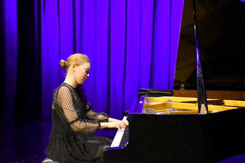Klavierspielerin auf der Bühne am Instrument