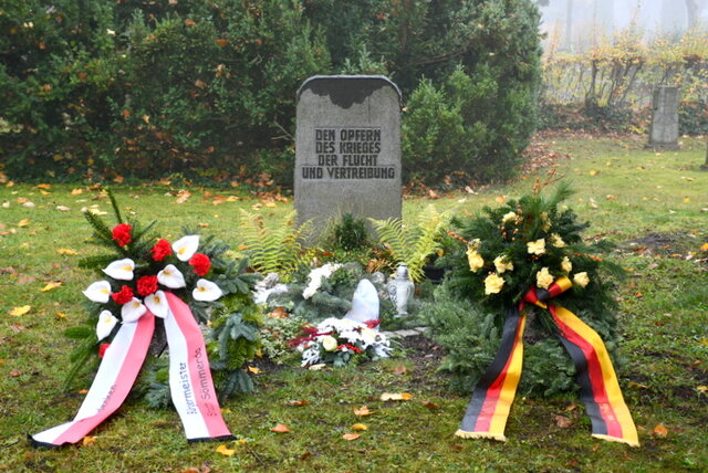 Vor dem Gedenkstein auf dem Sömmerdaer Friedhof mit der Aufschrift "Den Opfern von Krieg, Flucht und Vertreibung" liegen links und rechts zwei mit Tannengrün und Blumen geschmückte große Kränze. Der linke Kranz ist zudem mit einem rot-weißen Schmuckverband - den Farben der Stadt Sömmerda - versehen. Der rechte Kranz ist mit einem Band in Schwarz-Rot-Gold geschmückt. Er kommt von der Patenkompanie.