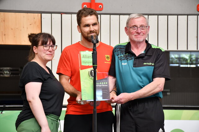 Projektmanagerin Julia Ansorg übergibt Steffen Kramer und Axel Panzner den Siegerpokal der 2. Olympiade der Allianz 'Thüringer Becken' in der Unstruthalle in Sömmerda.