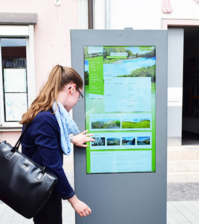 Bürgerin bedient die Informationssäule 