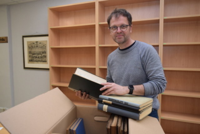 Ulf Molzahn mit gereinigten Büchern der Handbibliothek, die nun wieder einsortiert wurden.