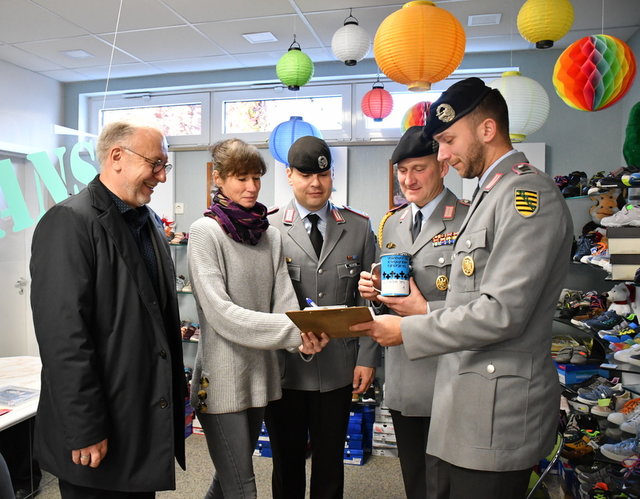 Bürgermeister Ralf Hauboldt, Major Christopher Richter, Oberstabsfeldwebel Sven Schandelmaier sowie Oberstabsgefreiter Tim Richter (v. l.) im Geschäft von Nancy Hanika, Inhaberin von Fans Schuhmoden.