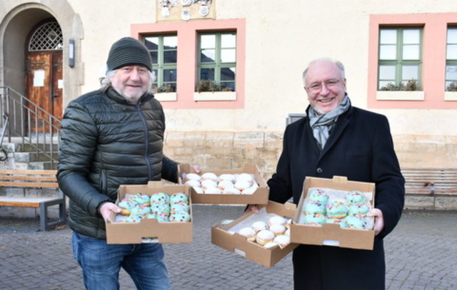 Bäckermeister und Bürgermeister mit Pfannkuchen-Kisten