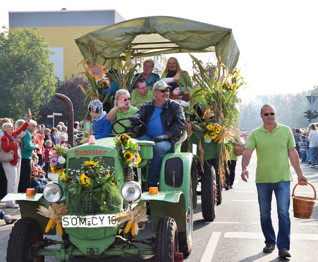 Geschmückter Traktor mit Anhänger beim Ernteumzug