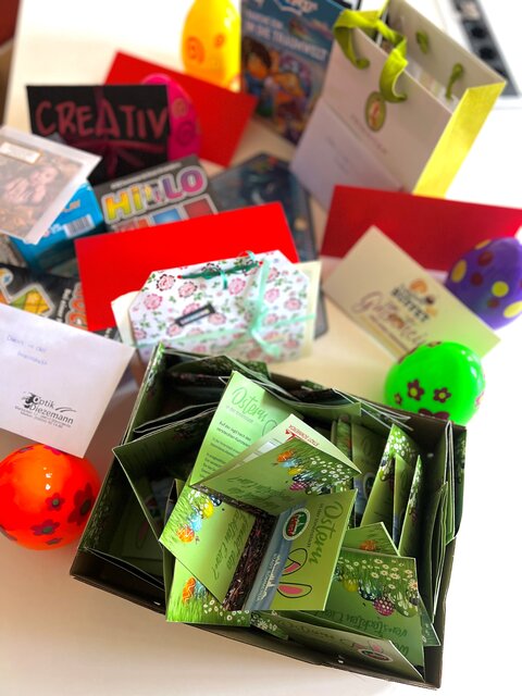 Gewinnpakete der Ostereiersuche in Sömmerda, bestehend aus Gutscheinen, Spielen, Geschenkverpackungen und bunten Ostereiern auf einem Tisch.