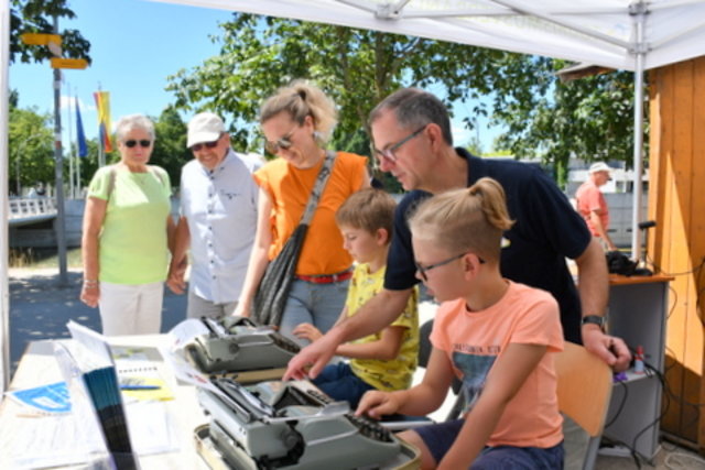 Kinder üben sich an mechanischer Schreibmaschine.