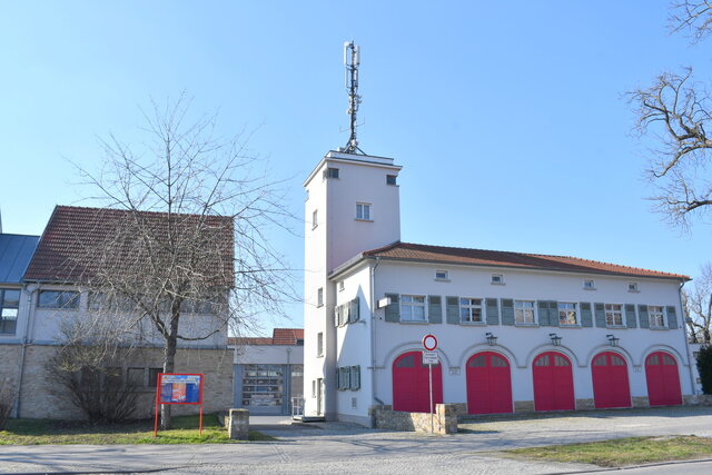 Feuerwehrgerätehaus Sömmerda Feuerwehrgerätehaus in Sömmerda mit fünf roten Toren, einem Turm und einer Antennenanlage unter blauem Himmel.