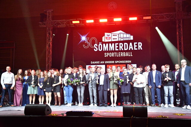 Gruppenbild nach den Auszeichnungen beim Sportlerball. Die ausgezeichneten Sportlerinnen und Sportler, Teams, Mannschaften und Sportfunktionäre sowie Vertreter der Stadt und der Sponsoren stehen gemeinsam in einer großen Gruppe auf der Bühne mit Blick zum Publikum.