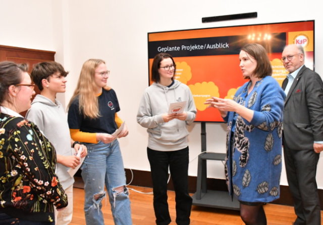 Julia Ansorg, Simeon Reimer, Nicola Ende, Katharina Schenk und Ralf Hauboldt stehen im Sitzungssaal im Gespräch zusammen.