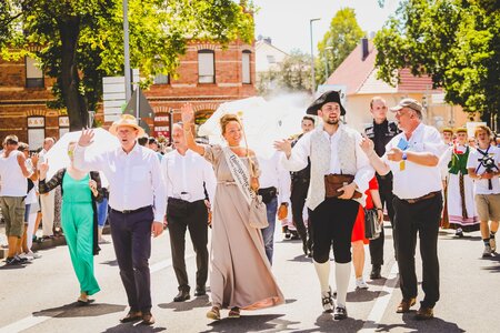 Menschen in historischen Kostümen bei einem Festumzug auf einer Straße in Sömmerda.