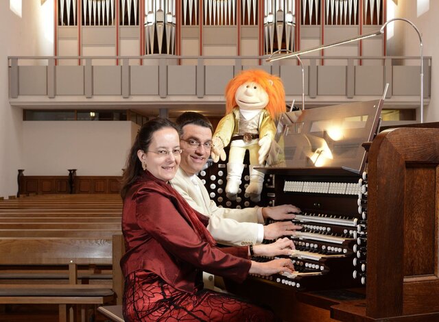 Iris und Carsten Lenz sitzen an einer Orgel in einer Kirche.