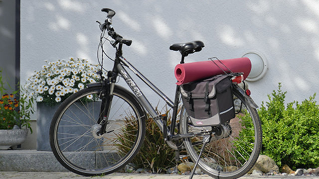 Fahrrad mit Gepäck steht vor einem Haus