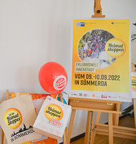 Plakate, Luftballons und Beutel mit dem Heimat shoppen-Logo