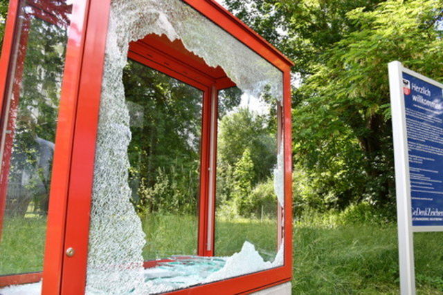 Vitrine mit eingeschlagener Scheibe und nebenstehender Tafel zum Audioguide