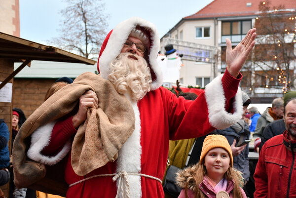 Der Weihnachtsmann in Nahaufnahme hält seinen Sack und begrüßt die Kinder
