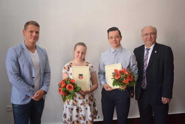 Christian Haase, Samira Busch, Johannes Fischer und Bürgermeister Ralf Hauboldt stehen mit den unterzeichneten Ausbildungsverträgen im Sitzungssaal. 