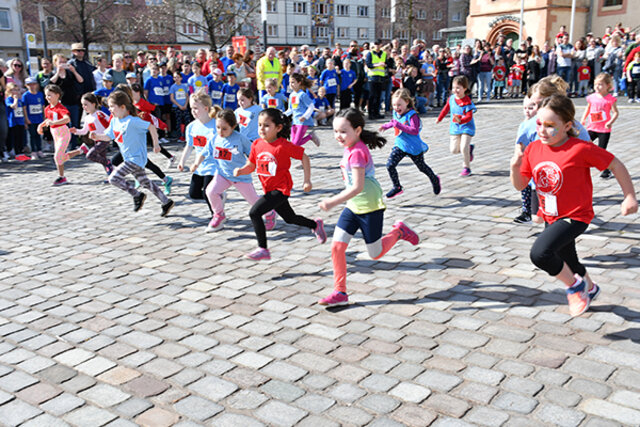 Kleine Mädchen rennen nach dem Startschuss über die Markstraße. Die Laufstrecke wird vom zahlreichen Publikum gesäumt.