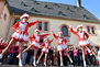 Eine der Tanzgruppen des Tanzsportvereins Sömmerda tanzen in Gardekostümen auf der Bühne vor dem Rathaus.