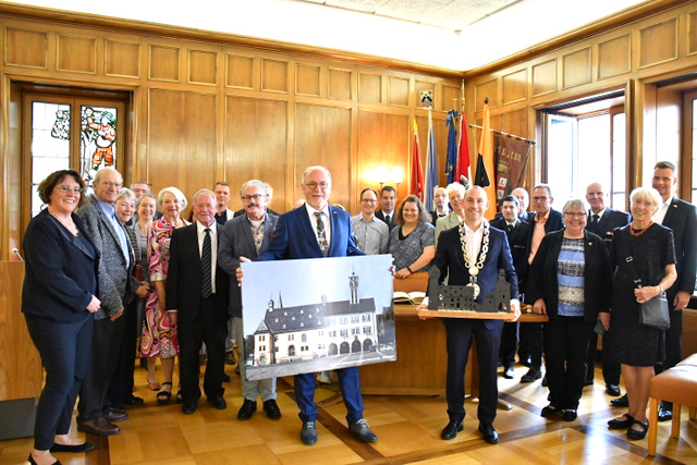 Die Bürgermeister der beiden Städte sowie Vertreter aus Sömmerda und Böblingen stehen gemeinsam fürs Foto im Festsaal des Rathauses. Sömmerdas Bürgermeister hält das Gastgeschenk von Böblingen in der Hand: eine großformatige Bildcollage mit dem Sömmerdaer und dem Böblinger Rathaus. Böblingens Oberbürgermeister zeigt das Sömmerdaer Gastgeschenk: ein längliches Holzunterteil mit eingebauter LED-Beleuchtung, auf dem vier Sehenswürdigkeiten der Stadt als schmale Gebäude stehen.