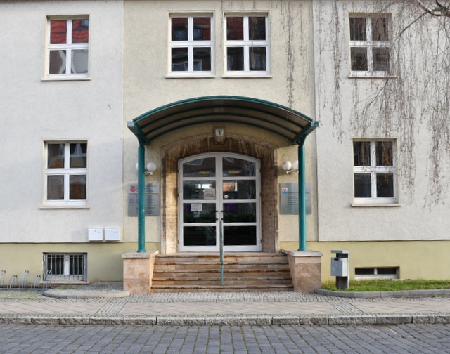 Das Verwaltungsgebäude in der Poststraße von vorn mit überdachtem Eingangsbereich.