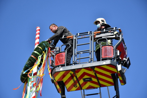 Kranz von Drehleiter aus an Maibaum-Spitze gehängt