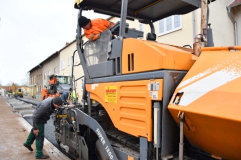 Der Asphaltfertiger, eine große Maschine, rollt im Rohrhammerweg.