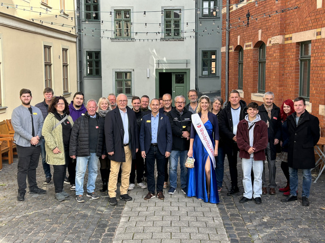 Teilnehmer der Sömmerdaer und Böblinger Delegation stehen in einer Gruppe in zwei Reihen hintereinander im Innenhof des Dreyse-Hauses. Eingerahmt sind sie rechts von der roten Backsteinfassade der Bibliothek. Links ist die sandsteinfarbene Fassade des Museumsgebäudes. Im Hintergrund ist der Eingang vom Innenhof aus ins Dreyse-Haus zu sehen.