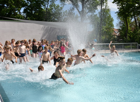 Kinder stürmen ins Wasserbecken