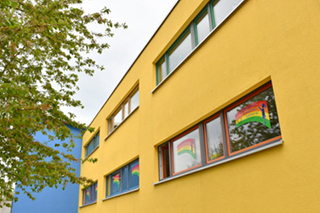 Blick auf fassade der Schule mit Schullogo in den Fenstern