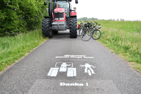 Traktor, Fahrräder und Slogan auf dem Unstrutradweg