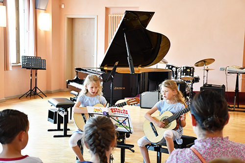 Junge Musikschülerinnen mit der Gitarre beim Konzert der Jüngsten einem Auftritt