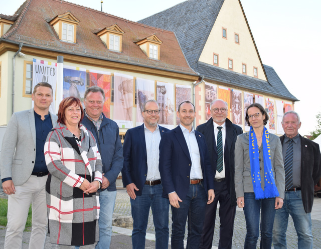 Vertreter aus Sömmerda und der Böblinger Delegation stehen vor dem Rathaus. An dessen Fassade hängen großformatige Fahnen mit aufgedruckten Kunstwerken.