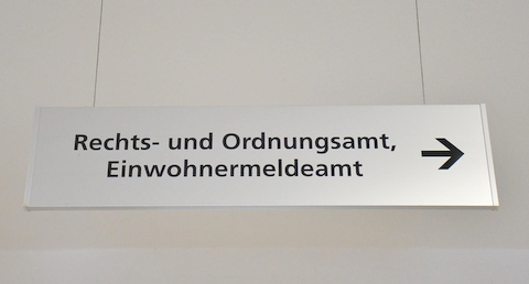 silberner, an der Decke hängender Wegweiser mit der Aufschrift Rechts- und Ordnungsamt, Einwohnermeldeamt